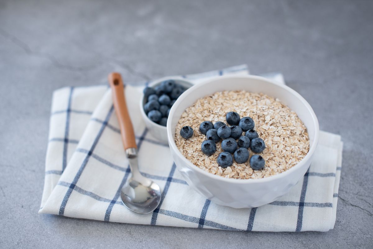 Homemade oatmeal with blueberries and strawberries in a bowl on gray concrete background. healthy breakfast
