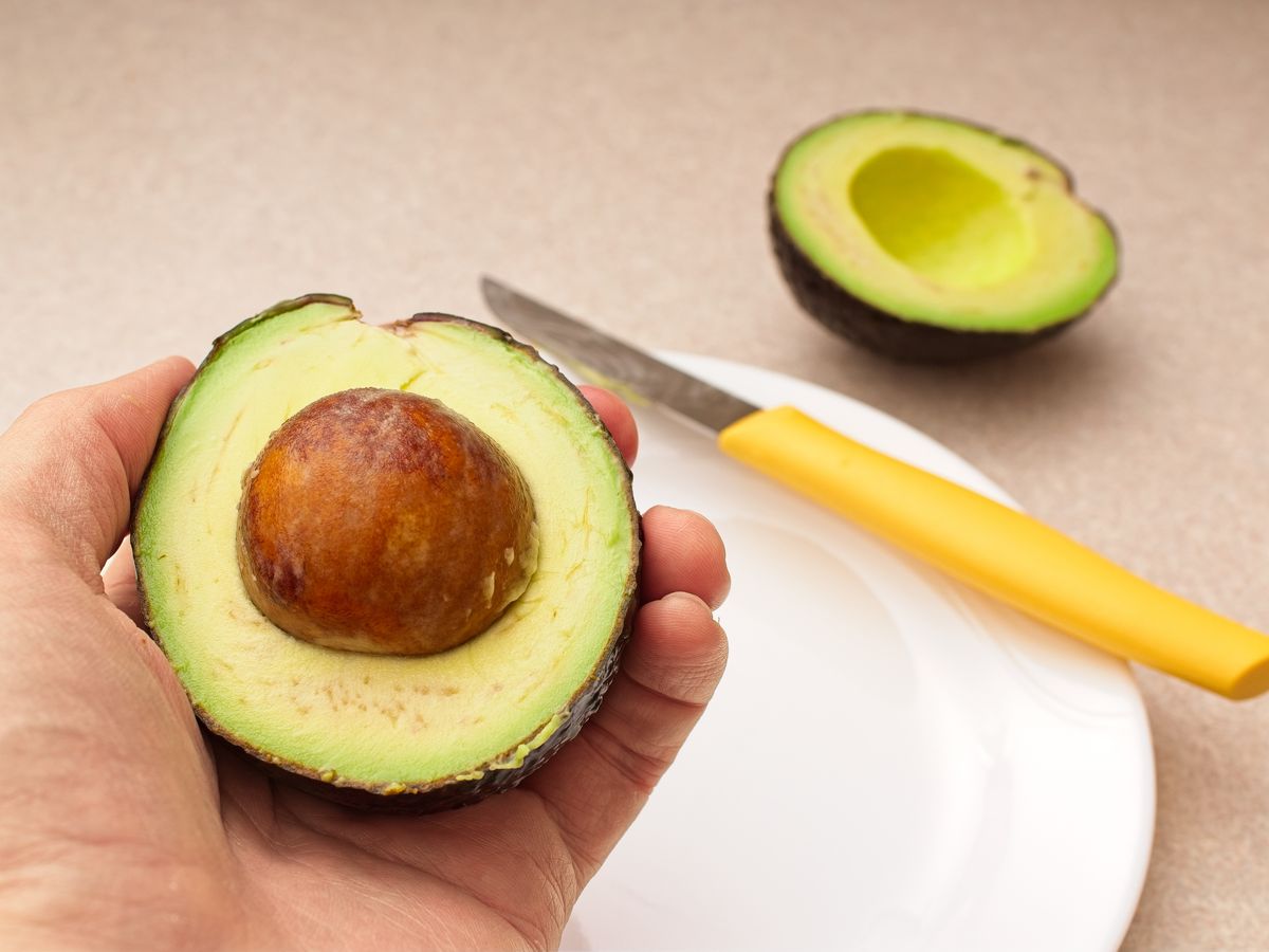 Ripe juicy avocado is being prepared in the kitchen. Avocado is a superfood packed with nutrients and healthy fats.