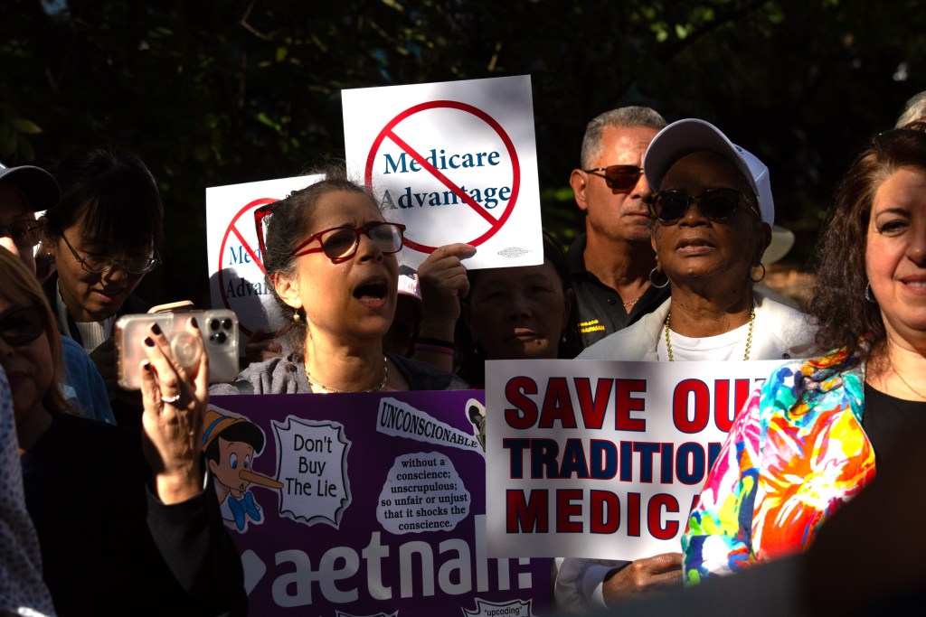 Retired city employees hold a rally in front of City Hall to protest plans to change the medical care plan.