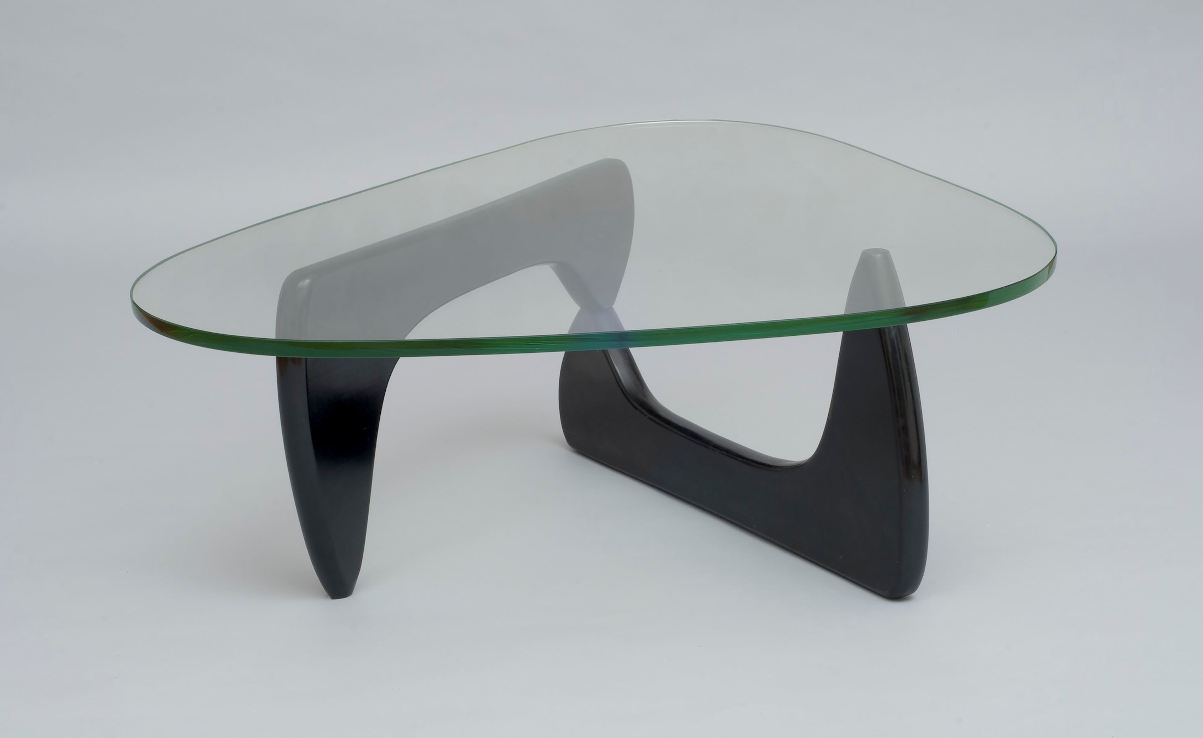 The coffee table (IN-50) was designed by Isamu Noguchi in 1944 and manufactured by Herman Miller Furniture Company. This example was built circa 1947-1953 and features ebonized birch, glass, and aluminum. (Courtesy of Isamu Noguchi Foundation and Garden/High Museum)