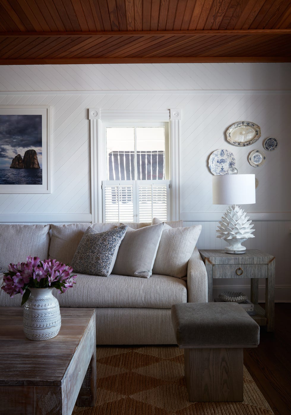 Cozy living room with sofa, coffee table, decorations and window.
