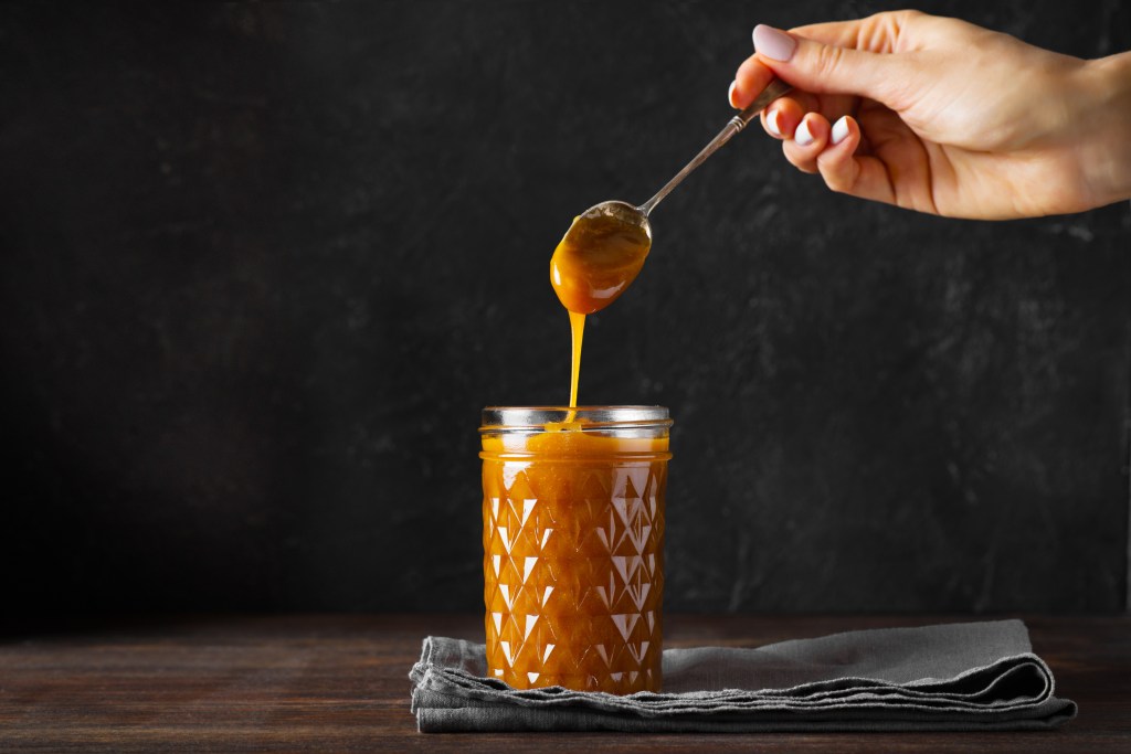 Pour liquid caramel into a glass bottle.