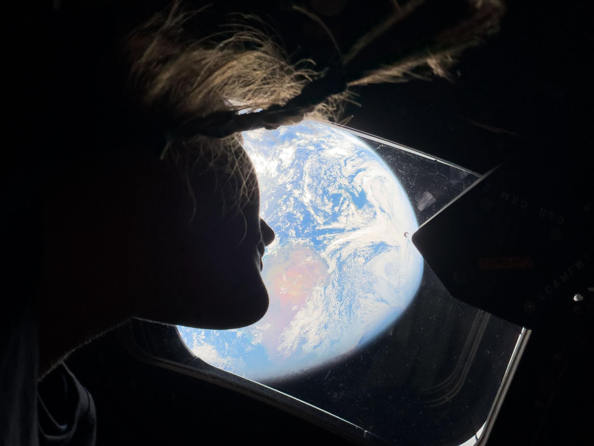Photo from Artemis II: NASA astronaut and Artemis II mission specialist Christina Koch looks back at Earth from one of the Orion spacecraft's main cabin windows as the crew moves towards the moon.