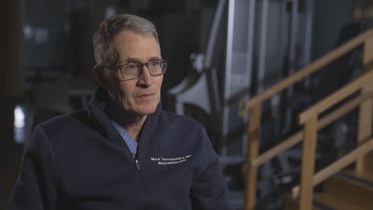 A man wearing glasses is sitting and looking away from the camera.