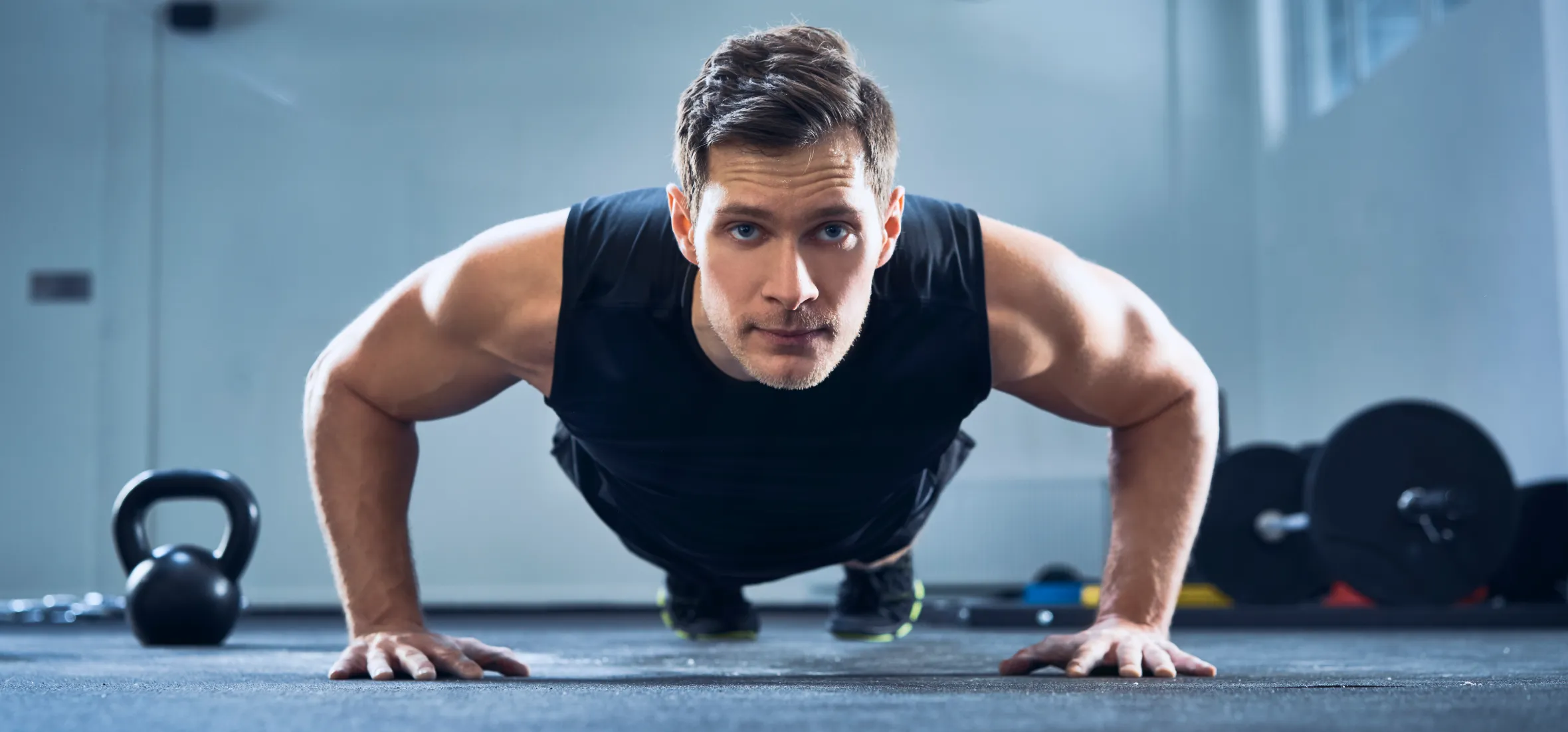 A man doing push-ups at the gym.