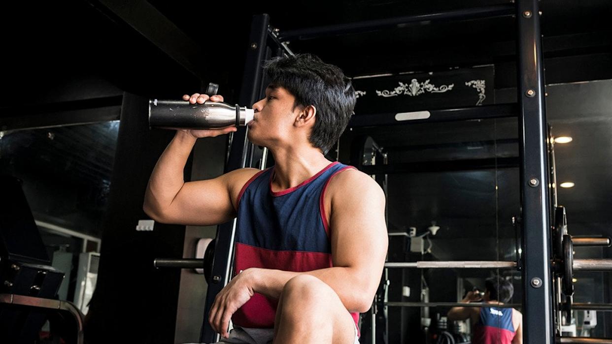 Young and healthy man drinking water inside the gym. - MDV Edwards // Shutterstock