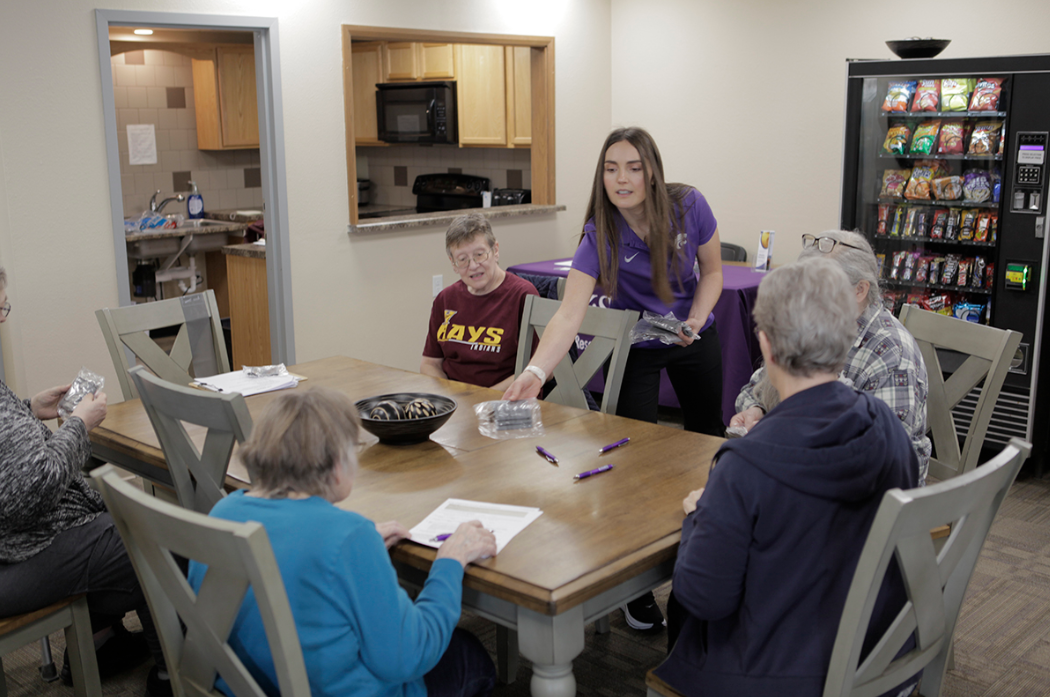Carissa Frazier, a community health worker at the K-State Ellis County Extension Office in Hays, hands out pedometers to participants in a Stamp Strong, Stay Healthy class in Hays. Photo courtesy of K-State Extension